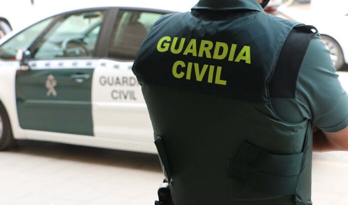 Arquivo - Un axente da Garda Civil, de costas, xunto a un vehículo oficial. - Garda Civil